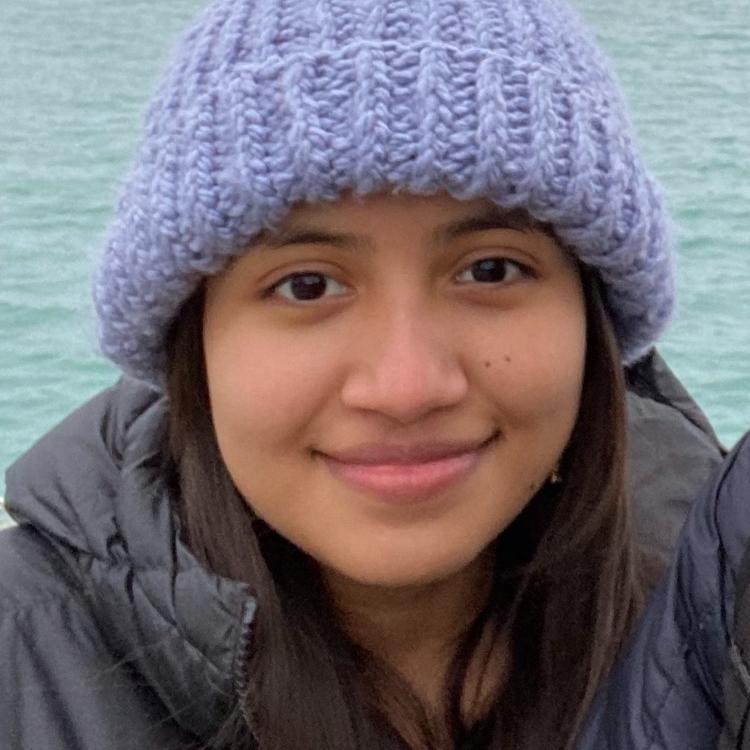 Samantha Carrizales depcited in front of a body of blue water
