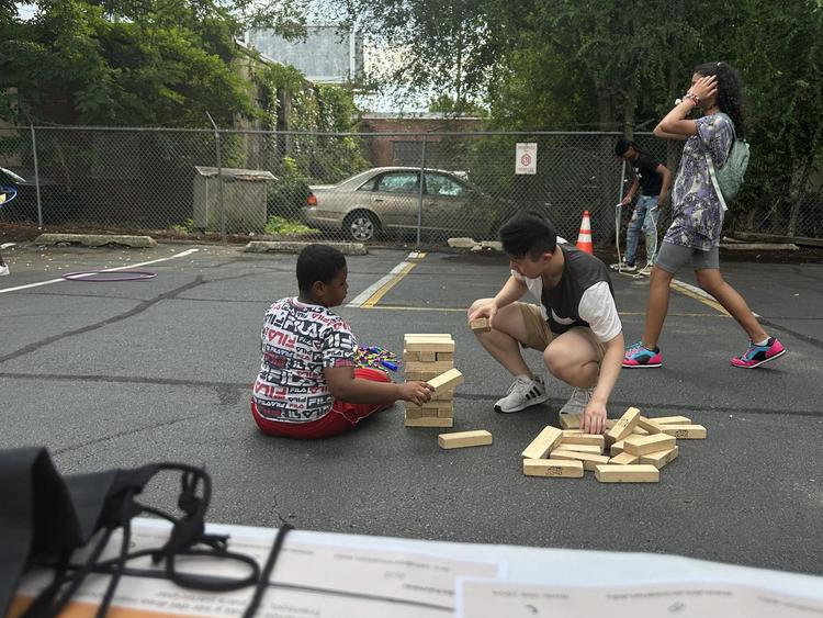 Lab manager Danny and child playing Jenga at a Block Party event.